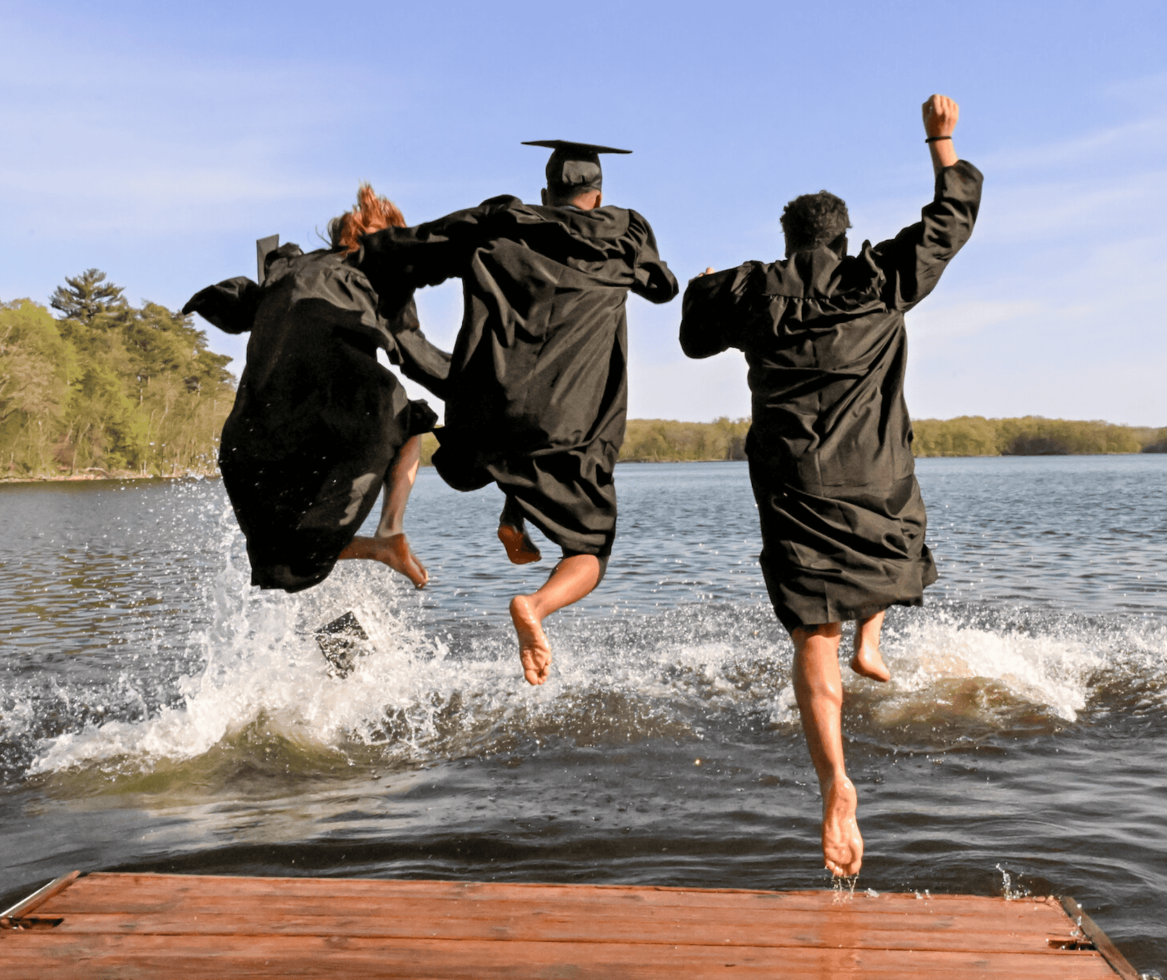 S J U students jump into lake Sag just minutes after graduation - a traditional Johnnie and Bennie celebration. 